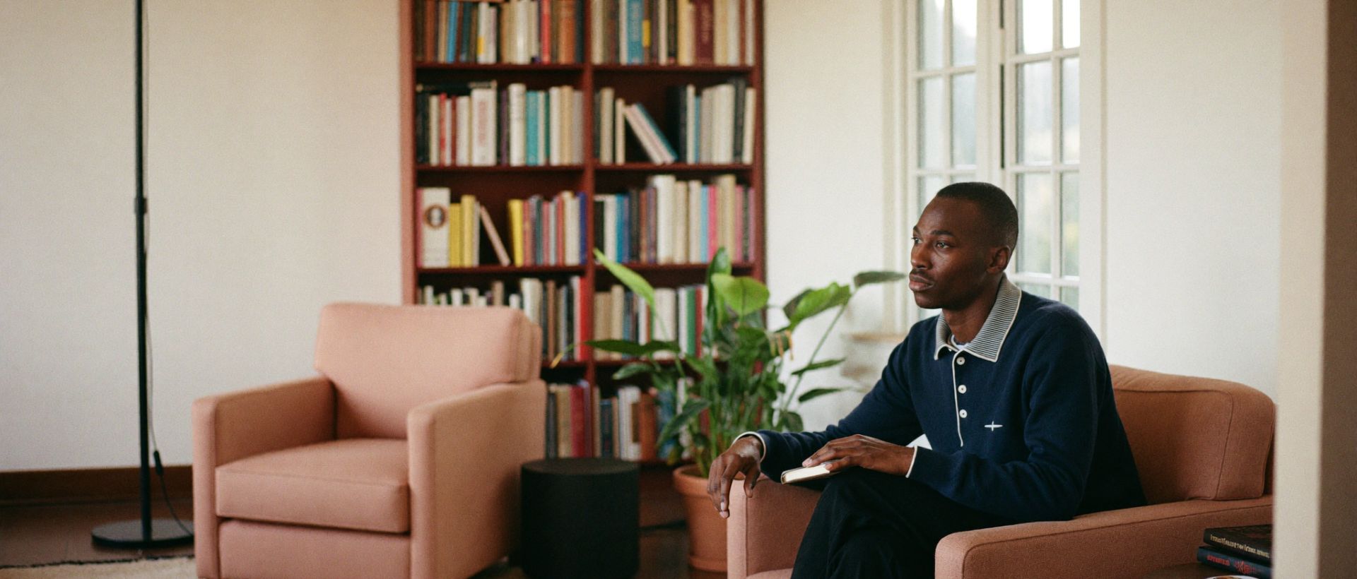 A calm consulting room with two armchairs set at an angle, a bookshelf and soft window light